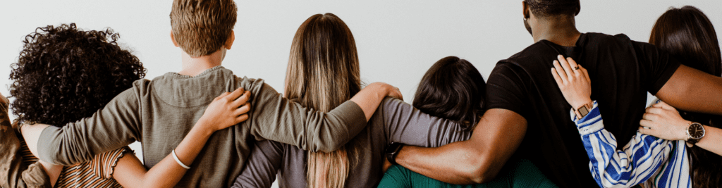 6 figures, shown from behind with arms around each other