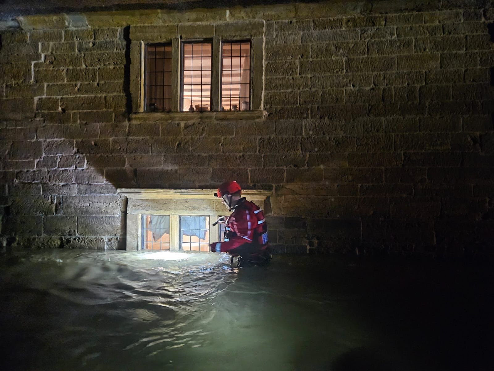 Emergency worker standing in flood water.