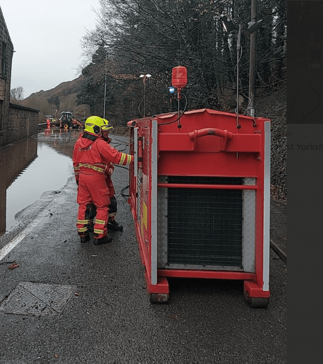 Firefighter using equipment to tackle flood water