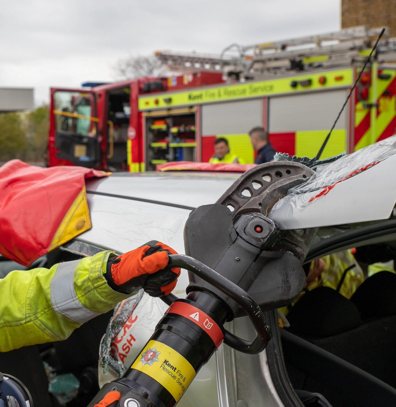 Firefighter using equipment on a car to gain access after a crash