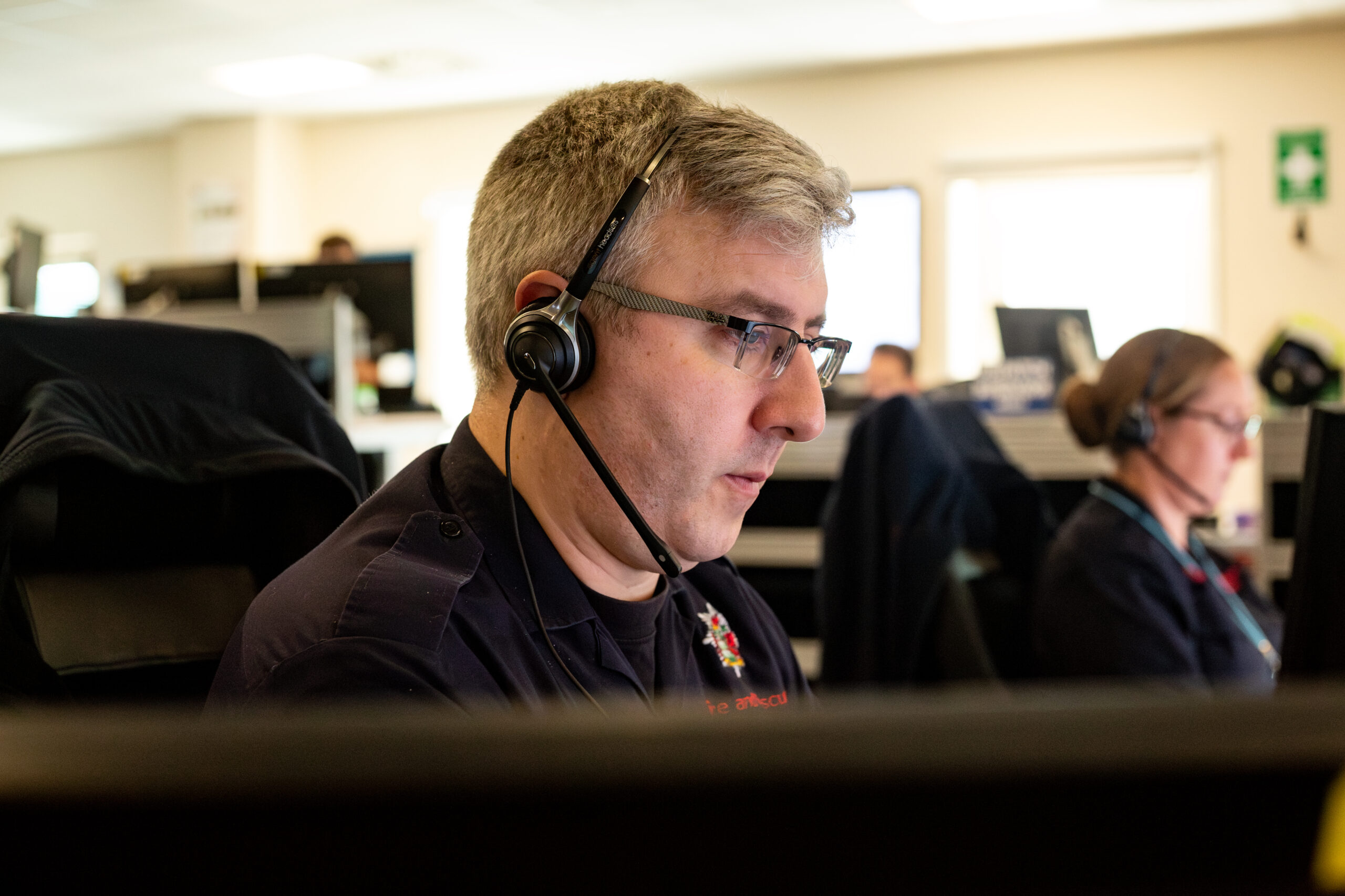 a man in a headset looks intently at the screen in front of him
