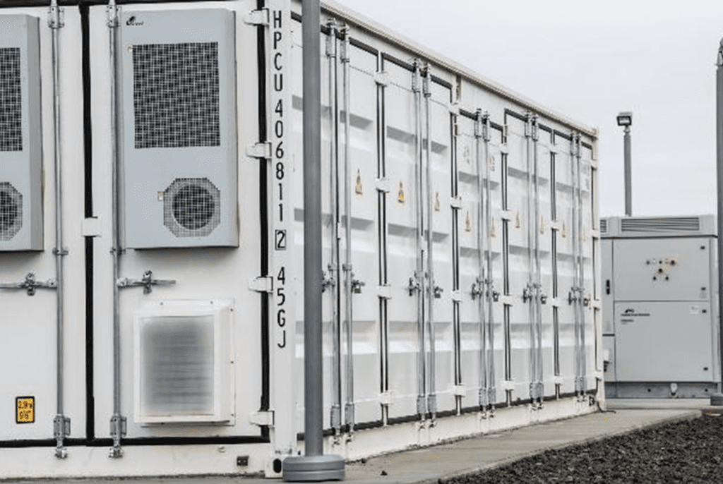 Close up of a white, cabinet-style BESS unit with doors on the outside allowing access