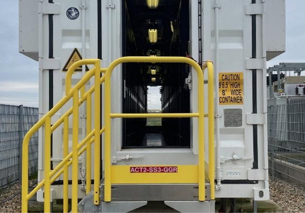 Close up of an internal access route of a BESS unit, showing a set of yellow, gated metal steps